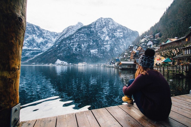 žena sedící u horského jezera